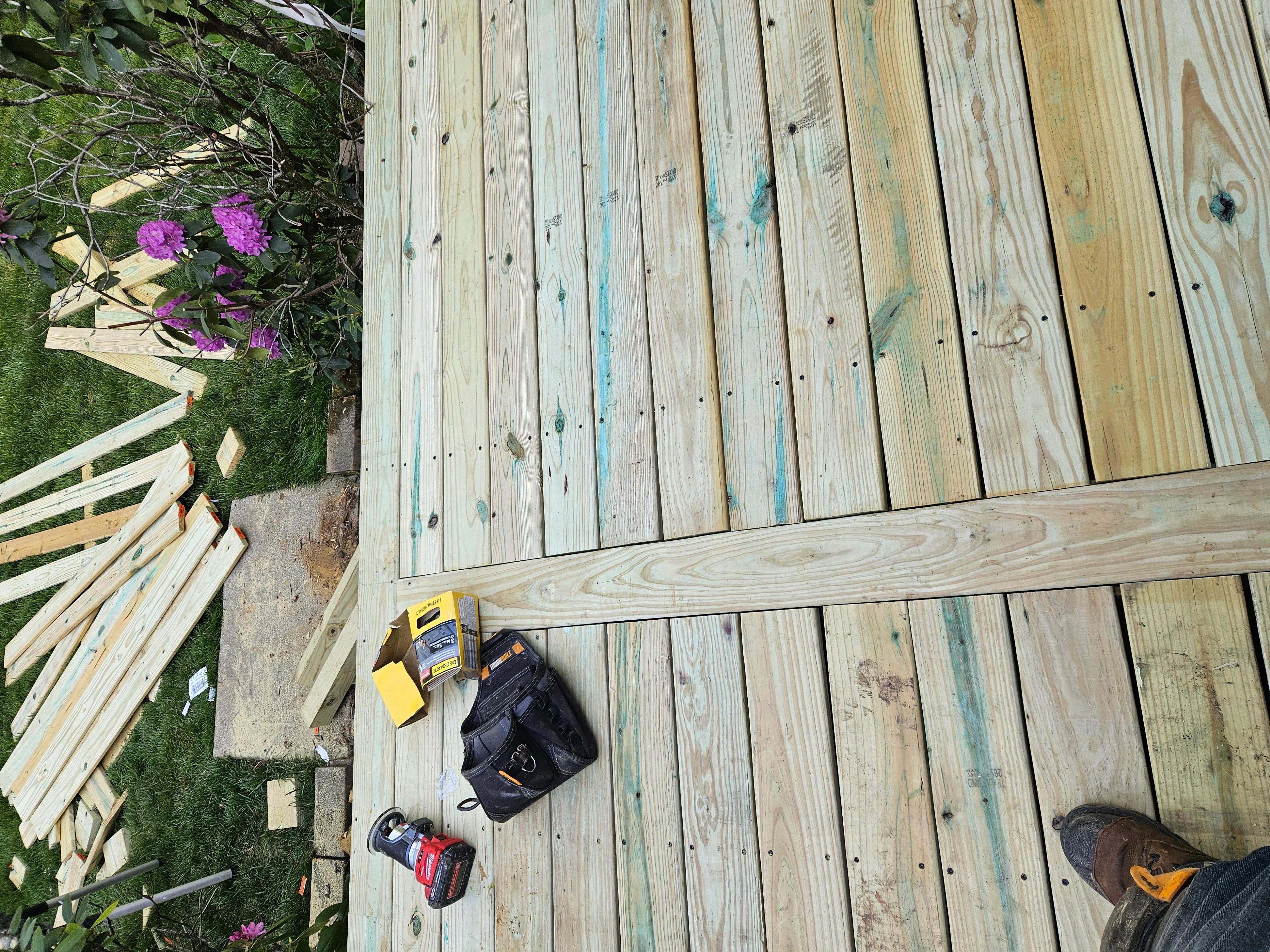 Pressure-treated wood deck construction with dimensional lumber framing and fasteners