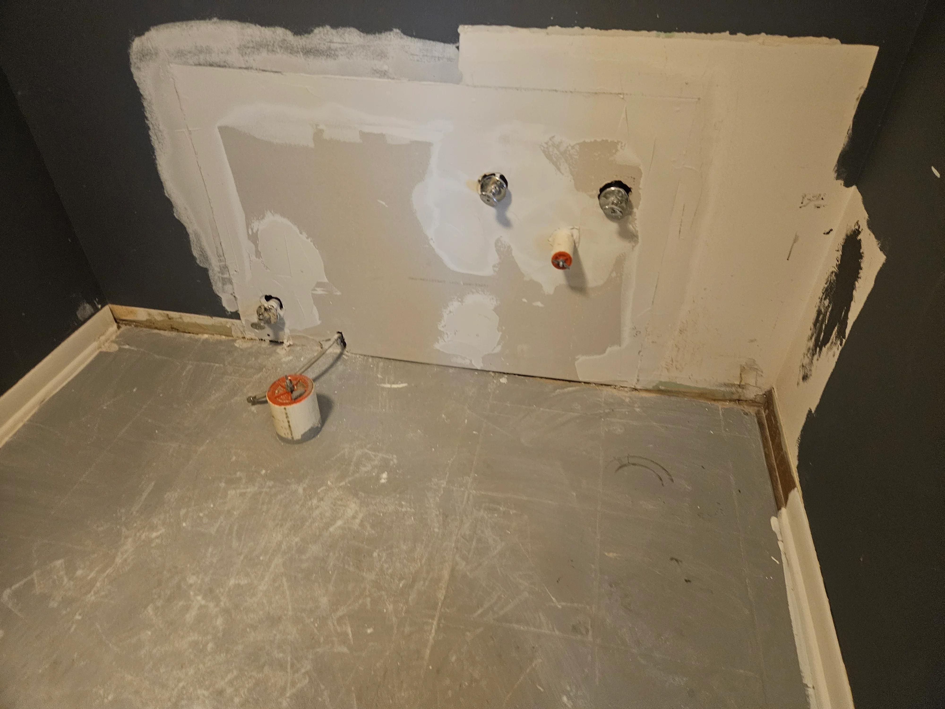 Drywall installation with taped joints, electrical outlets, and fire-rated covers in progress